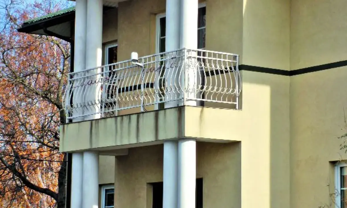 Nowy balkon z ozdobną balustradą, którego obróbka czoła balkonu została starannie wykonana.