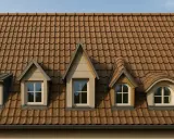 Dach z brązowej dachówki, na którym widać cztery lukarny: dwie trapezowe, jedna trójkątna i jedna zaokrąglona.