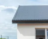 Nowoczesny dom z szarym dachem z blachy. Montaż dachówki przebiegł sprawnie, tworząc solidne i estetyczne pokrycie.