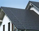 Nowoczesny dach z dachówki ceramicznej w ciemnym kolorze, chroniący dom przed deszczem i słońcem.