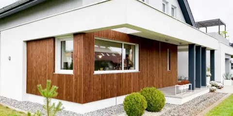 Nowoczesny dom z drewnianą elewacją, gdzie deski sosnowe tworzą ciepły kontrast z bielą.
