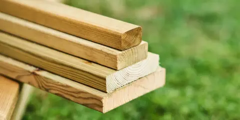 Stos desek z tarcicy iglastej, gotowy do budowy tarasu lub altany.