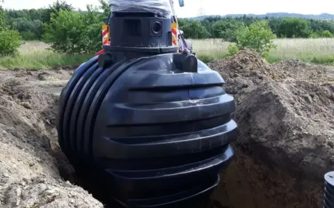 Montaż podziemnego zbiornika na deszczówkę, kluczowego elementu do odprowadzenia wody z rynien.