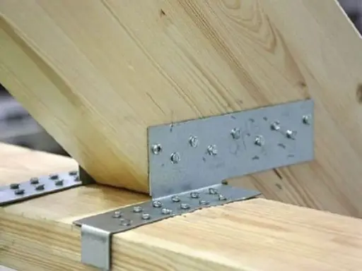 Solidne zaciosy ciesielskie łączą drewniane belki, zapewniając stabilność konstrukcji.