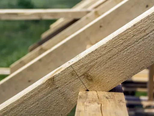 Drewniane krokwie dachu, zaznaczone linie wskazują, jak obliczyć zacios na krokwi, by zapewnić stabilność konstrukcji.