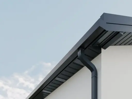 Nowoczesne rynny kwadratowe w kolorze grafitowym odprowadzają wodę z dachu białego domu.