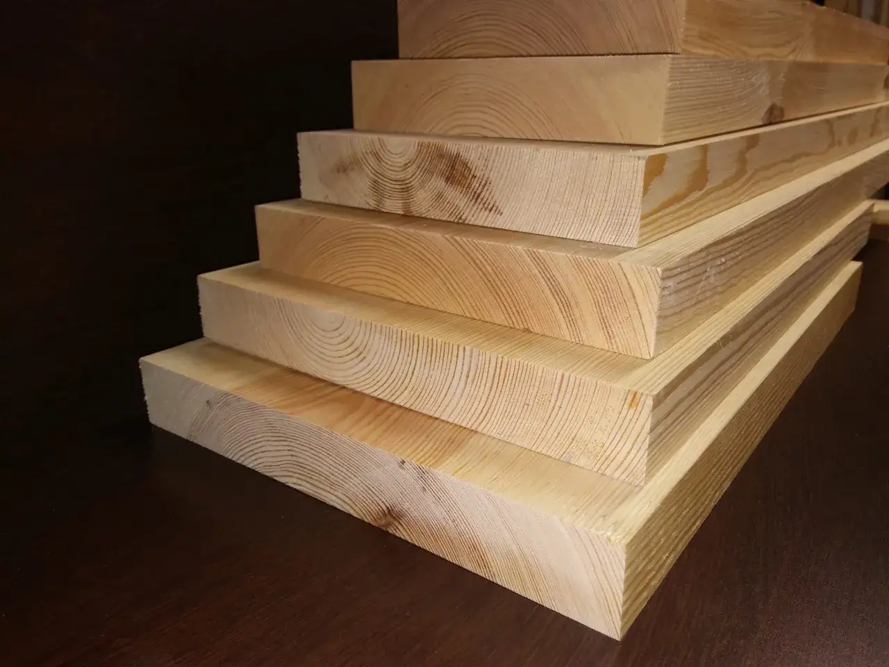 Pięć desek sosnowych ułożonych schodkowo. Widoczne słoje drewna i naturalny kolor. Idealne na projekt DIY.